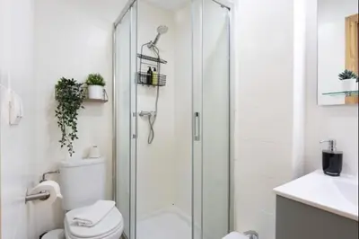 a white bathroom with a shower and a toilet at Isaac Peral by Staycare in Rota