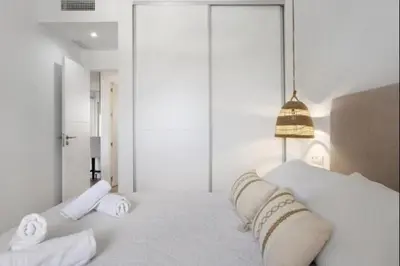 a white bedroom with a large bed with two pillows at Isla Candor free parking by Staycare in Rota