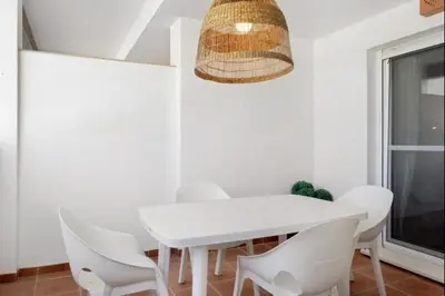 a white dining room with a white table and white chairs at Isla Candor free parking by Staycare in Rota