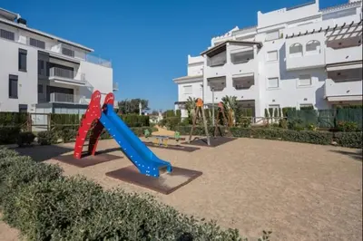 a playground with a slide in front of a building at Isla Candor free parking by Staycare in Rota