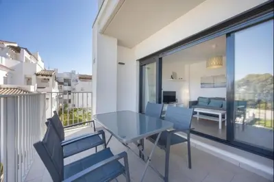 a dining table and chairs on a balcony at La Atalaya free parking by Staycare in Rota