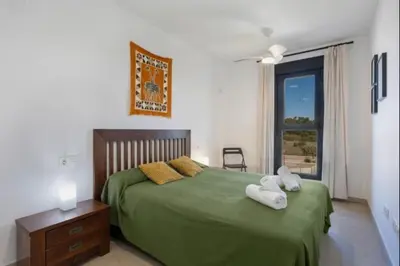 a bedroom with a green bed with towels on it at La Atalaya free parking by Staycare in Rota