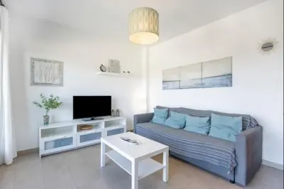 a living room with a couch and a tv at La Atalaya free parking by Staycare in Rota