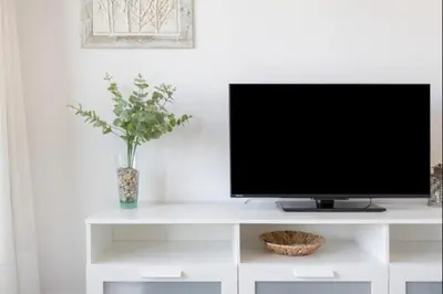 a tv sitting on top of a white entertainment center at La Atalaya free parking by Staycare in Rota