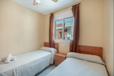 a bedroom with two beds and a window at Ecija Playa Rota by Staycare in Rota