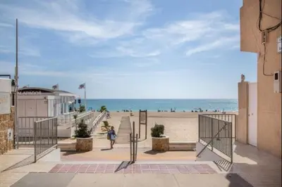 a woman walking down the stairs to the beach at Ecija Playa Rota by Staycare in Rota