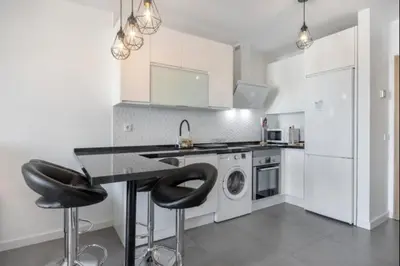 a kitchen with a table and two bar stools at Nerea Rota free parking by Staycare in Rota