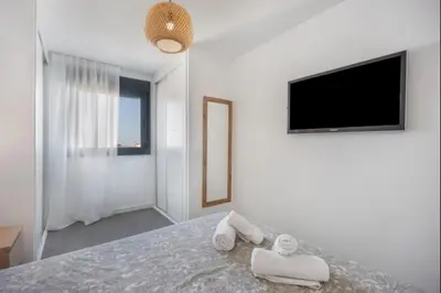 a white bedroom with two towels on a bed at Nerea Rota free parking by Staycare in Rota
