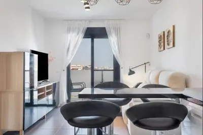 a room with a table and chairs and a television at Nerea Rota free parking by Staycare in Rota