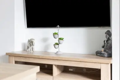 a table with two statues on top of it with a television at Paraíso Candor free parking by Staycare in Rota