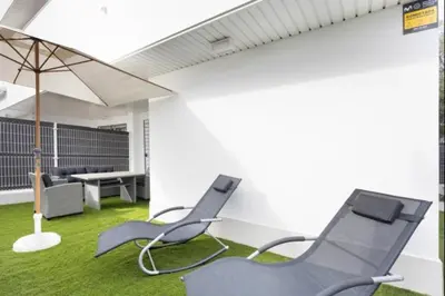 a living room with two chairs and an umbrella at Paraíso Candor free parking by Staycare in Rota