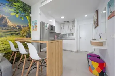 a kitchen with a bar with white cabinets and white chairs at Paraíso Candor free parking by Staycare in Rota