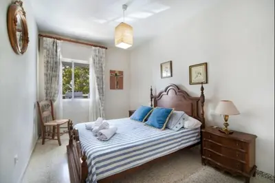 a bedroom with a large bed with blue pillows at Pinar del Mar by Staycare in Rota