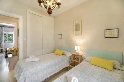 a bedroom with two beds and a chandelier at Pinar del Mar by Staycare in Rota