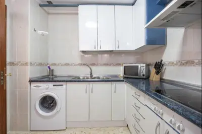a kitchen with a washing machine and a microwave at Sorolla Rota free parking by Staycare in Rota