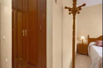 a bedroom with a bed and a wooden door at Sorolla Rota free parking by Staycare in Rota