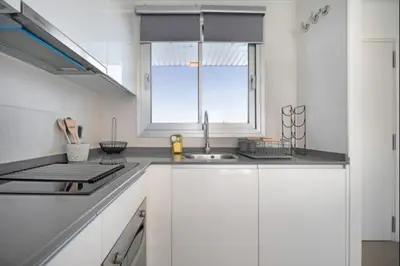 a white kitchen with a sink and a window at Luar Candor free parking by Staycare in Rota