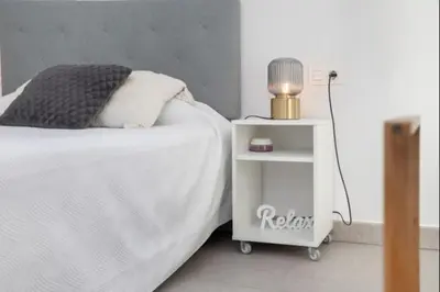 a bed with a side table with a lamp on it at Luar Candor free parking by Staycare in Rota