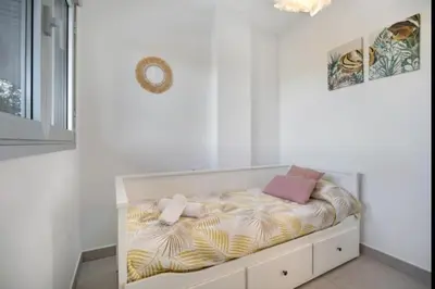 a bed in a white room with avertisement at Luar Candor free parking by Staycare in Rota