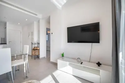 a white living room with a television on a wall at Luar Candor free parking by Staycare in Rota