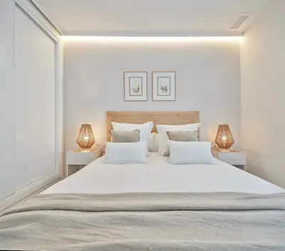 a bedroom with a large white bed with two lamps at Wehost - Costaluz APARTAMENTO JAZMINES in El Puerto de Santa María
