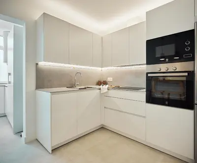 a white kitchen with a sink and a stove at Wehost - Costaluz APARTAMENTO JAZMINES in El Puerto de Santa María
