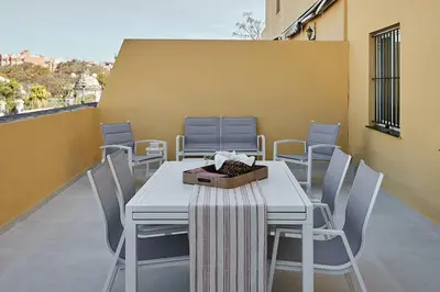 a white table and chairs on a balcony at Wehost - Costaluz APARTAMENTO JAZMINES in El Puerto de Santa María