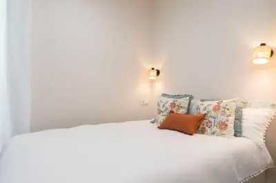 a bedroom with a white bed with pillows at Apartoyou - Centro Moderno in El Puerto de Santa María