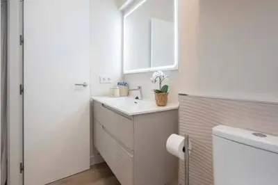 a white bathroom with a sink and a mirror at Apartoyou - Centro Moderno in El Puerto de Santa María