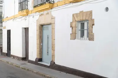 a white building with a blue door on a street at Apartoyou - Centro Moderno in El Puerto de Santa María