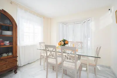 a dining room with a glass table and chairs at Apartoyou - Torre Vistahermosa in El Puerto de Santa María