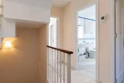 a hallway with a staircase and a bathroom with a window at Apartoyou - Torre Vistahermosa in El Puerto de Santa María