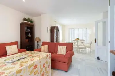 a living room with a red couch and a table at Apartoyou - Torre Vistahermosa in El Puerto de Santa María