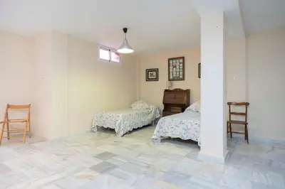 a room with two beds and a table and chairs at Apartoyou - Torre Vistahermosa in El Puerto de Santa María