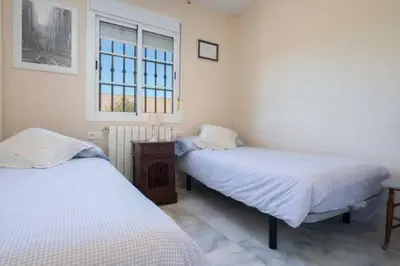a bedroom with two beds and a window at Apartoyou - Torre Vistahermosa in El Puerto de Santa María