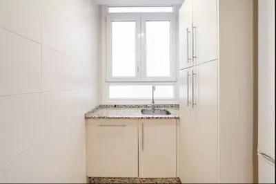 a white kitchen with a sink and a window at Piso Cádiz Playa Victoria in Cádiz
