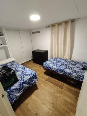 a bedroom with two beds and a wooden floor at Casita Playa Ballena in Rota