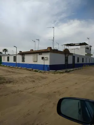 a blue and white building on the side of a dirt road at Casita Playa Ballena in Rota