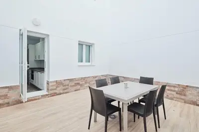 a dining room with a white table and chairs at Cádiz, ciudad y playa in Cádiz