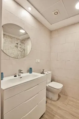 a bathroom with a sink and a toilet and a mirror at Cádiz, ciudad y playa in Cádiz