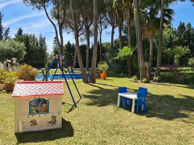 a play area with a toy dog house and a swing at Villa Serena - Casa rural en Arcos con piscina, barbacoa, chimenea in Arcos de la Frontera