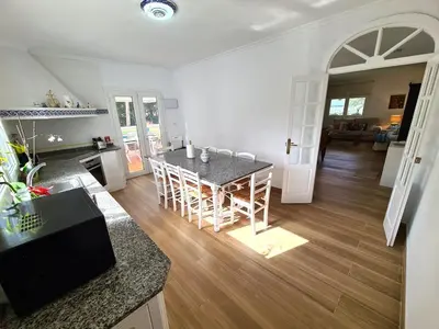 a kitchen and living room with a table and chairs at Villa Serena - Casa rural en Arcos con piscina, barbacoa, chimenea in Arcos de la Frontera