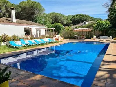 a swimming pool with blue chairs and a house at Villa Serena - Casa rural en Arcos con piscina, barbacoa, chimenea in Arcos de la Frontera