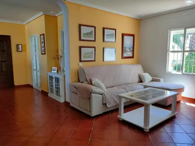 a living room with a couch and a table at Villa con piscina junto a la playa in Roche