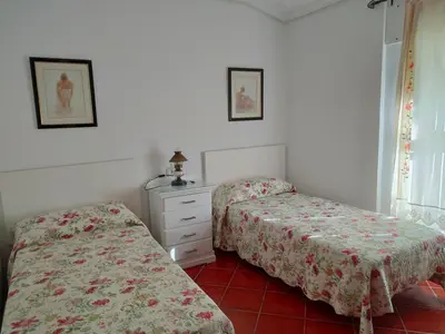 two twin beds in a room with a dresser at Villa con piscina junto a la playa in Roche
