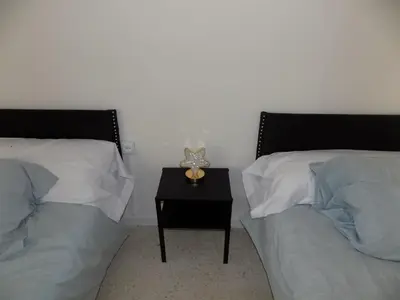 abedroom with two beds and a table with a cat toy at Plaza del Rey Apartments in San Fernando