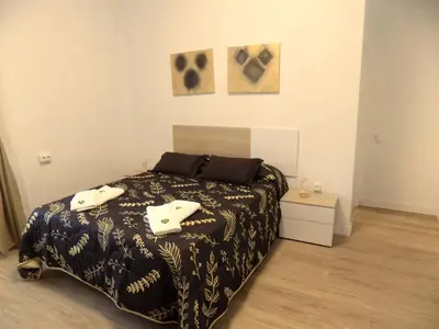 a bedroom with a bed with a black and white blanket at Plaza del Rey Apartments in San Fernando
