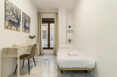 a small room with two beds and a desk at Allo Apartments San Lucas Parking Piscina Centro 2 habitaciones in Jerez de la Frontera