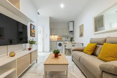 a living room with a couch and a table at Allo Apartments San Lucas Parking Piscina Centro 2 habitaciones in Jerez de la Frontera
