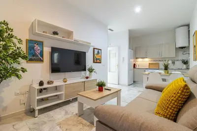 a living room with a couch and a tv at Allo Apartments San Lucas Parking Piscina Centro 2 habitaciones in Jerez de la Frontera